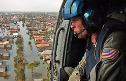 A U.S. Coast Guardsman searches for survivors in New Orleans in the aftermath of Katrina.